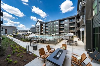 an outdoor patio with tables and chairs and a swimming pool